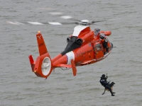 In caso di emergenza, siamo qui per te Un soccorritore viene calato in mare da un elicottero