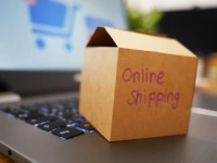 Uno scatolone su una tastiera di portatile. La tua attività di vendita online diventa il tuo lavoro principale