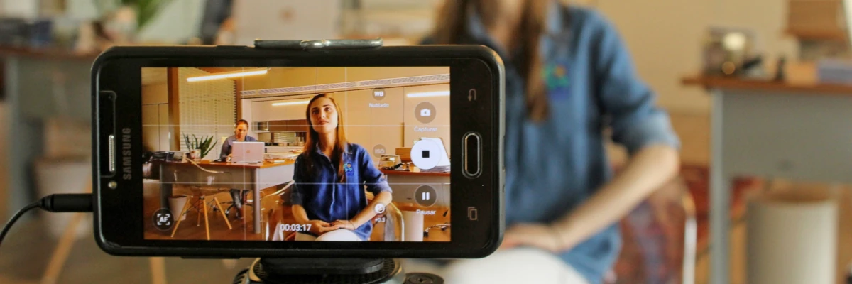 I tuoi video per il web sono uno strumento formidabile di promozione Lo schermo di un cellulare mentre riprende una ragazza in uno studio professionale. I tuoi video per il web sono uno strumento formidabile di promozione