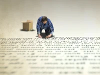 Ricerca e sostituzione di un testo nei file Uomo che compone testo su un enorme pavimento. Ricerca ed eventualmente sostituisce una stringa specifica all'interno di tutti i file testuali di una cartella specificata, con le sue sottocartelle